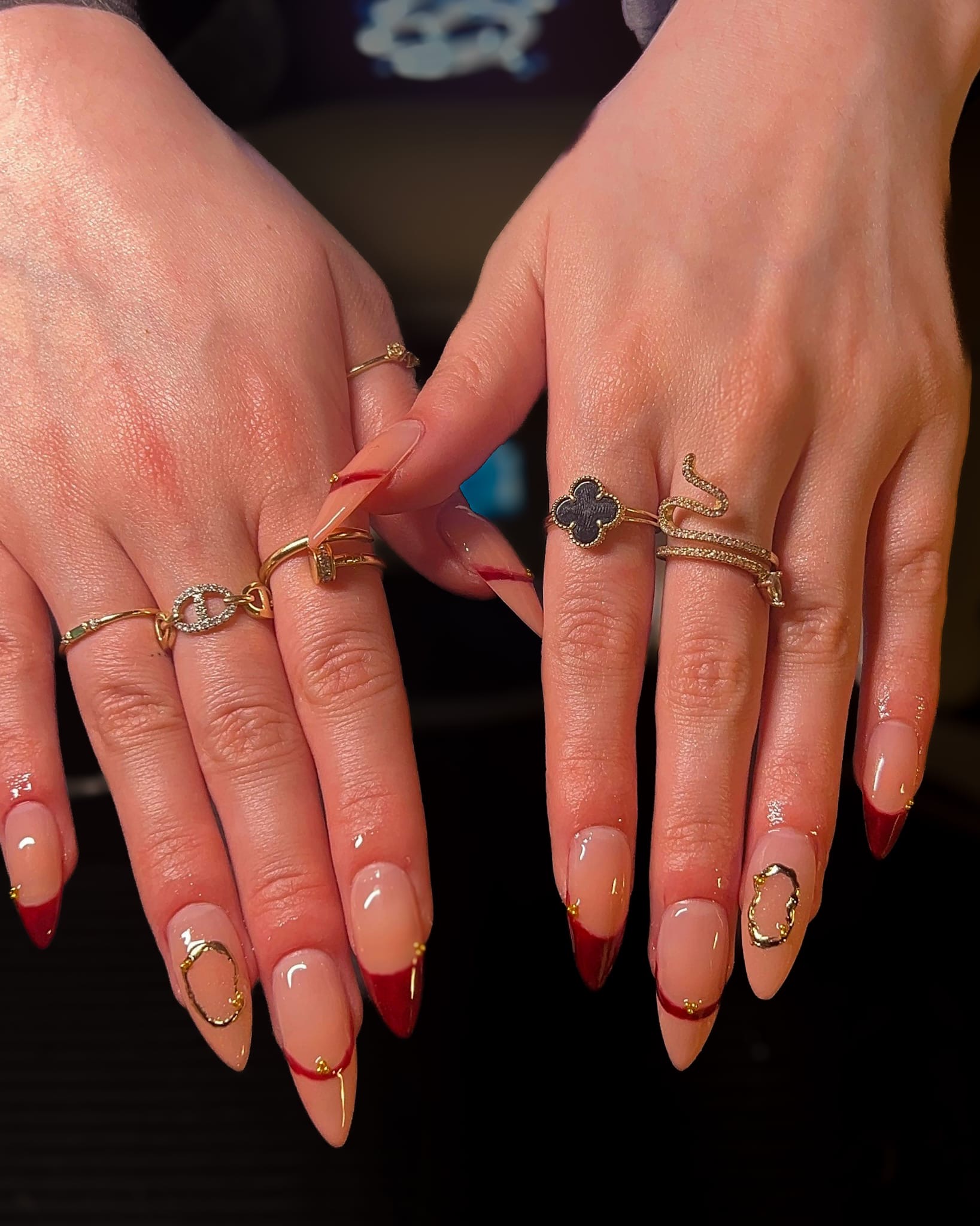 Red French tip nail design with gold details